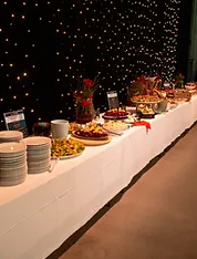Ein langer Tisch mit Tellern und einem lecker angerichteten Buffet